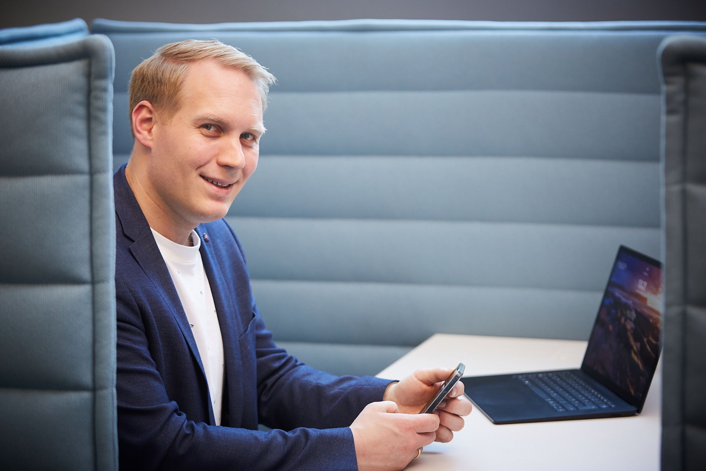 Peter Bonner in einer modernen Business Lounge mit Laptop.